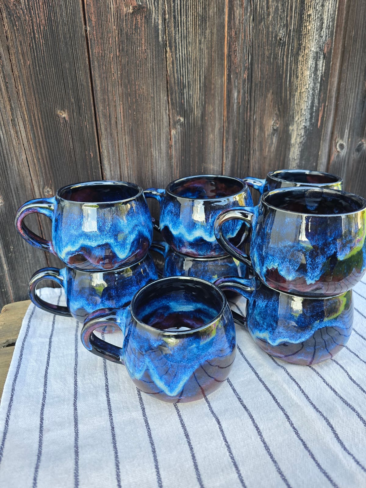 Gruppe handgetöpferter Becher mit tiefblauer Kobalt-Laufglasur