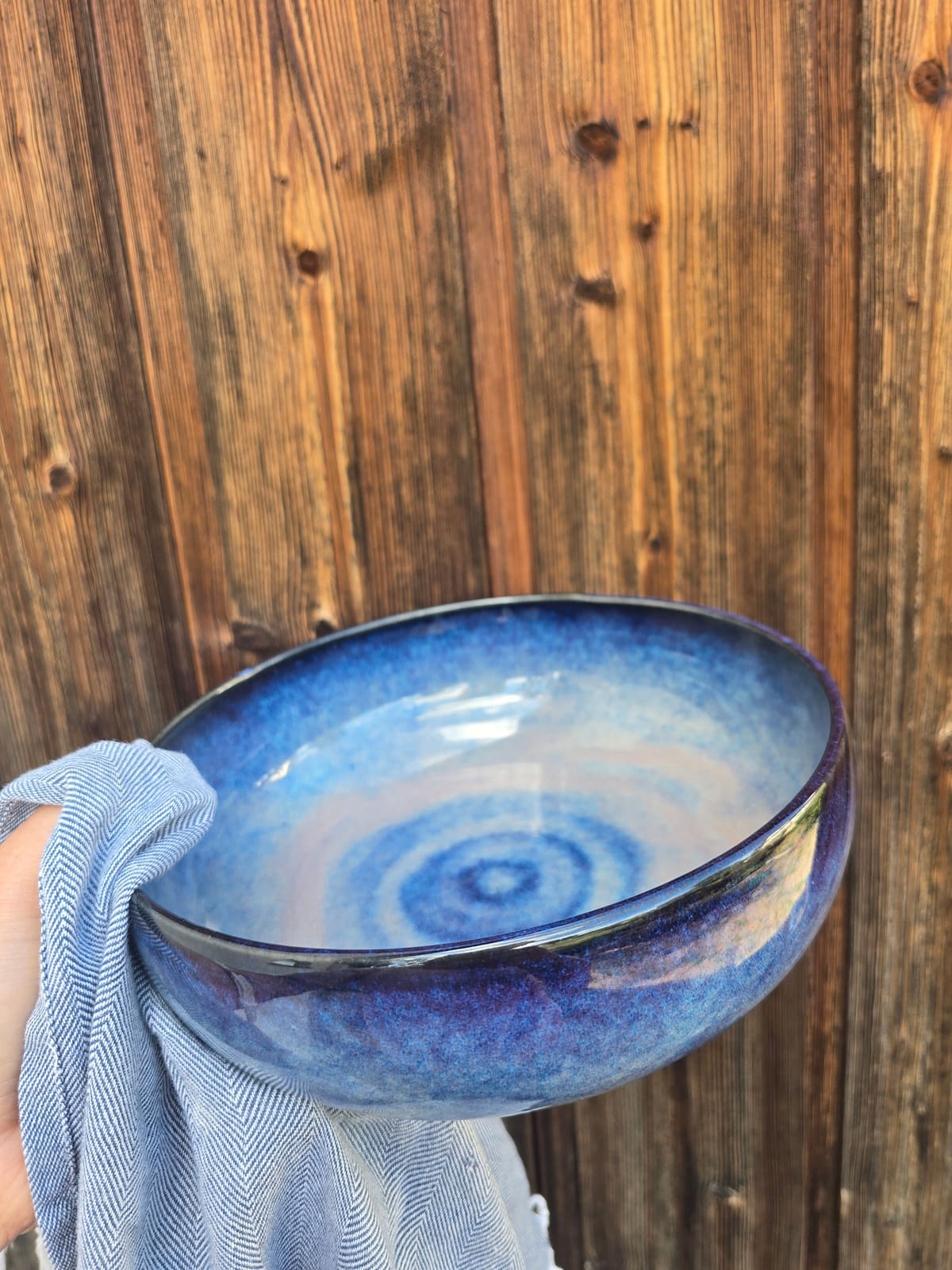 Flache Schale mit blauer Wirbelglasur auf einem Tuch