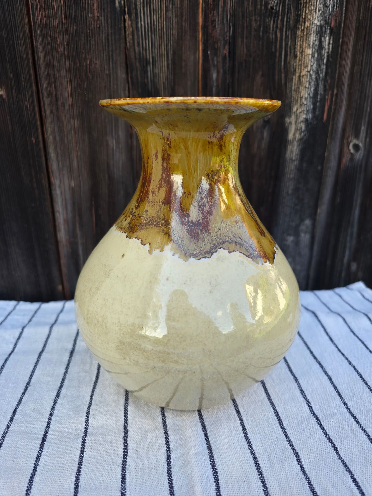 Hohe Vase mit ockerfarbener Laufglasur auf cremefarbenem Körper